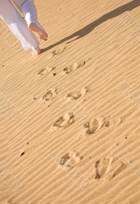 girl waking on the beach - footprints