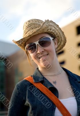 female wearing a hat and sunglasses outdoors