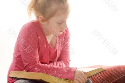 little girl is reading a book