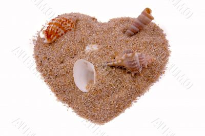 Heart from sand with cockleshells on white.