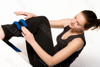 Woman is binding weights on her leg