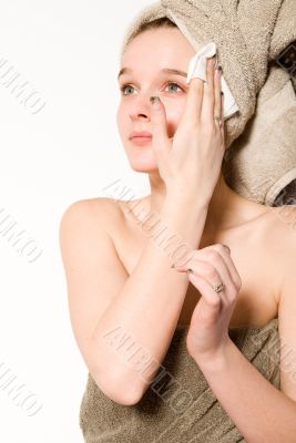 Young girl is cleaning her face