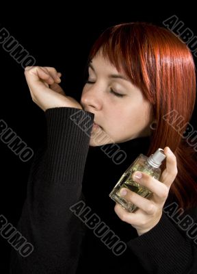 Girl smelling parfume from her hand