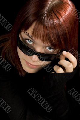 Girl looking through sunglasses.