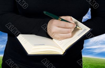 Female hand writing in a notebook