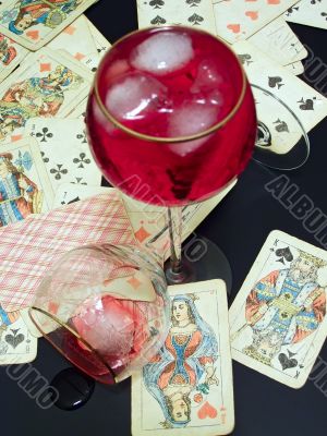 Broken glass, wine with ice and cards