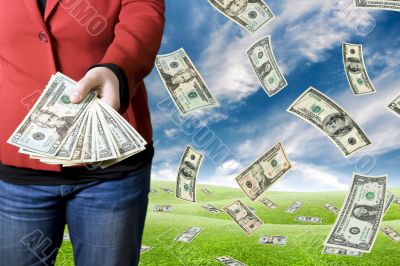 Girl picking up money falling from the sky