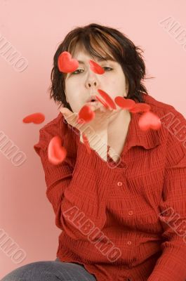 young beautiful woman blowing hearts away