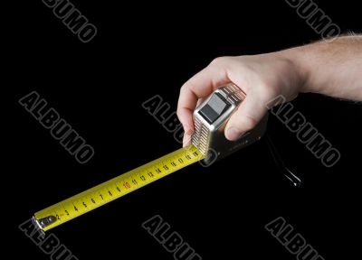 Measuring tape in hand.