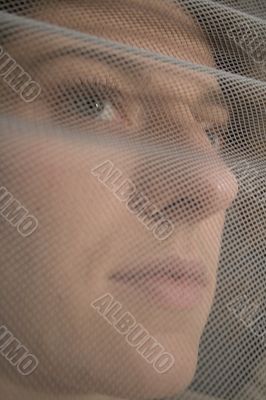 female face behind a net