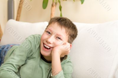 Happy teenager lie on sofa at home