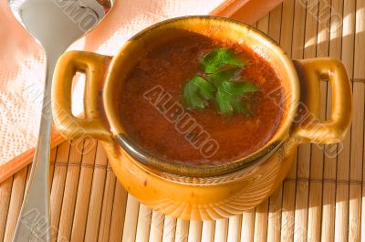 Cup of tomato soup on bamboo serviette.