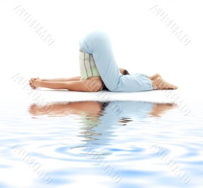 halasana plow pose on white sand