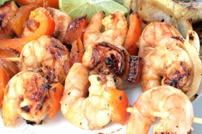 Grilled prawns on bamboo sticks served with salad and grilled ve