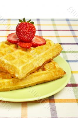 Waffles and strawberries on green plate
