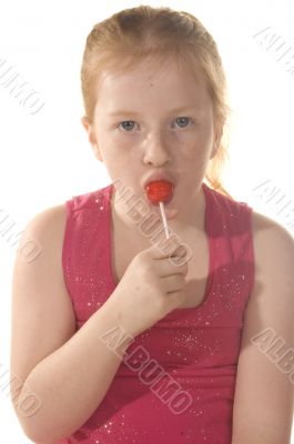 little girl is eating a lollypop