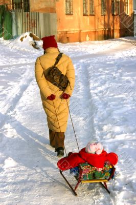 woman carries child in sled