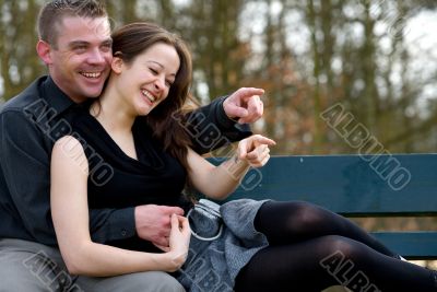 Young couple on a bench having fun