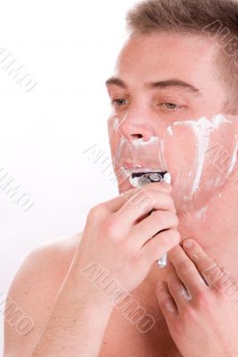 Man is shaving his chin