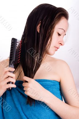 Woman is brushing her hair and looking down