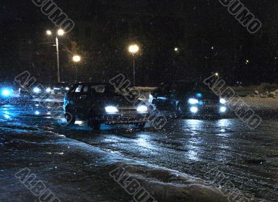 Cars in night blizzard.