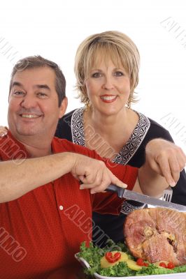 couple carving a ham