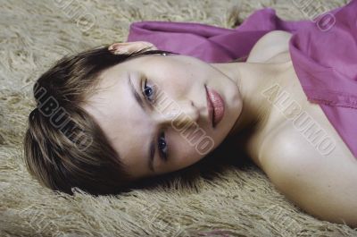 Pretty young woman lying on the carpet
