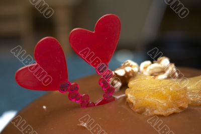 Glazed chocolate cake with two red lovely hearts