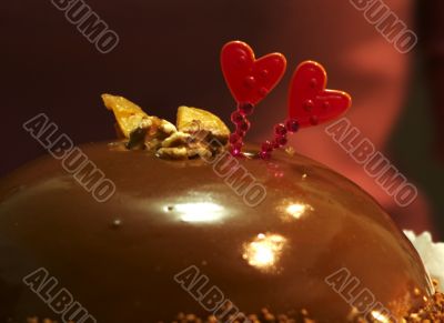 Glazed chocolate cake with two red lovely hearts
