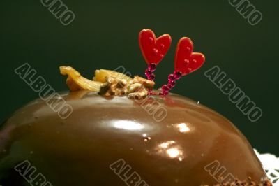Glazed chocolate cake with two red lovely hearts