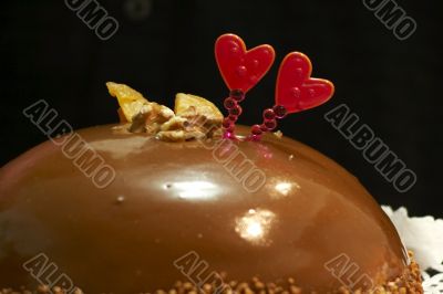 Glazed chocolate cake with two red lovely hearts