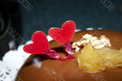 Glazed chocolate cake with two red lovely hearts