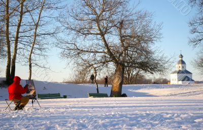 artist painting a chapel from life in winter