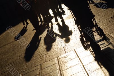 Shadows of people walking on the city street