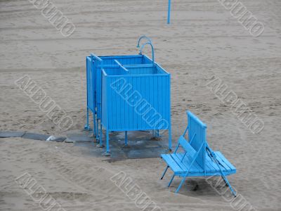 Shower booth and bench on a beach.