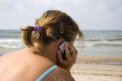 Woman talking by phone in beach