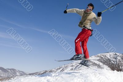 Snow Skier Jumping Against Blue Sky
