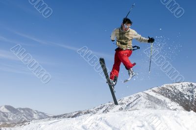 Snow Skier Jumping Against Blue Sky