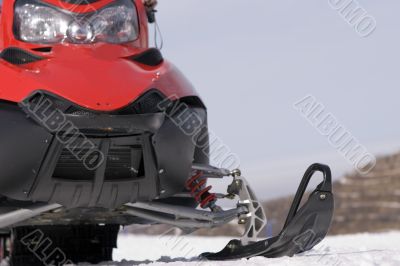Red snowmobile in winter mountains