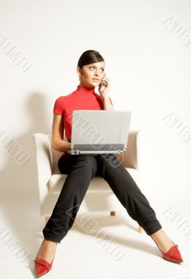 Atractive brunet businesswoman with Laptop and phone