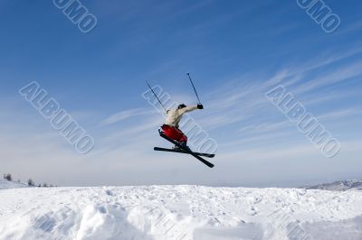 Snow Skier Jumping Against Blue Sky