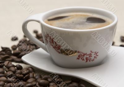 Cup of coffee and grains over sackcloth