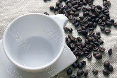 Cup of coffee and grains over sackcloth