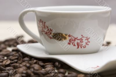 Cup of coffee and grains over sackcloth