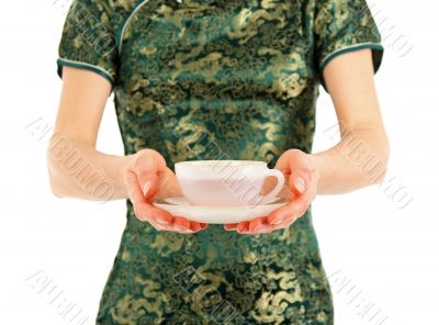 Woman in Chinese dress offering a cup of tea