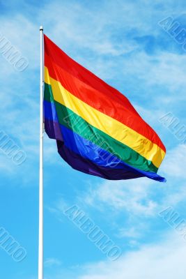 Rainbow gay pride flag on the blue sky