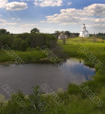 Church at hill over meadow near to river