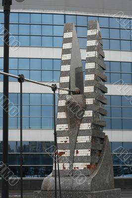 sculpture of modern berd on bridge near glass building