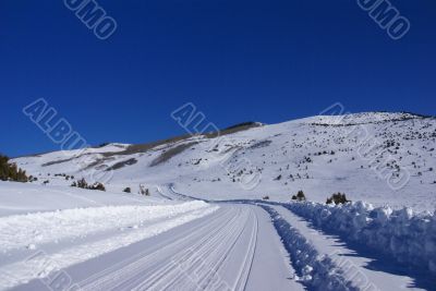 Tracks on snow covered road in mountain