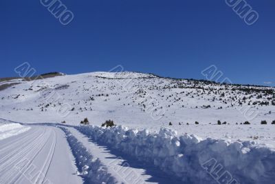 Tracks on snow covered road in mountain